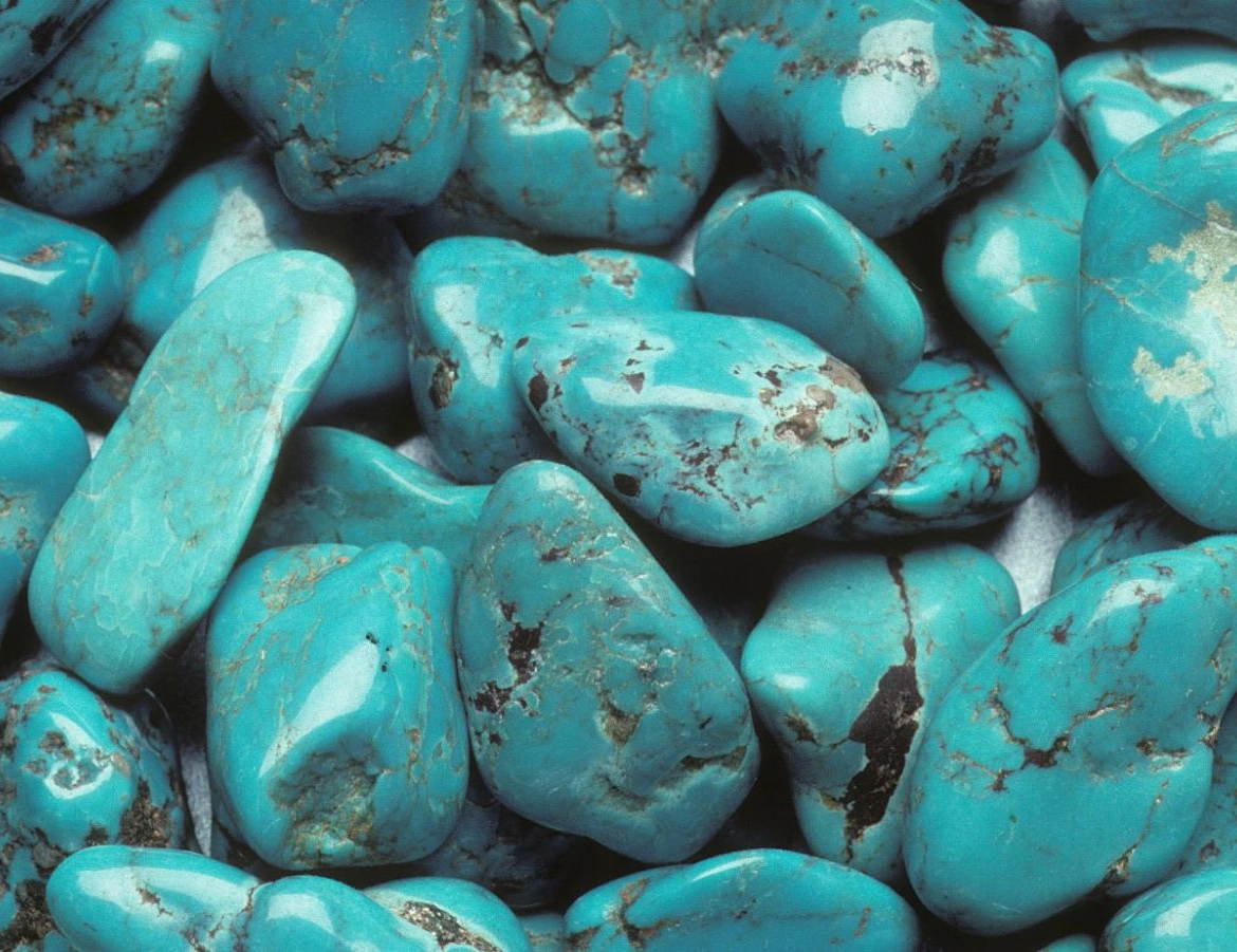 Close-up of polished turquoise stones with natural brown and black veining.