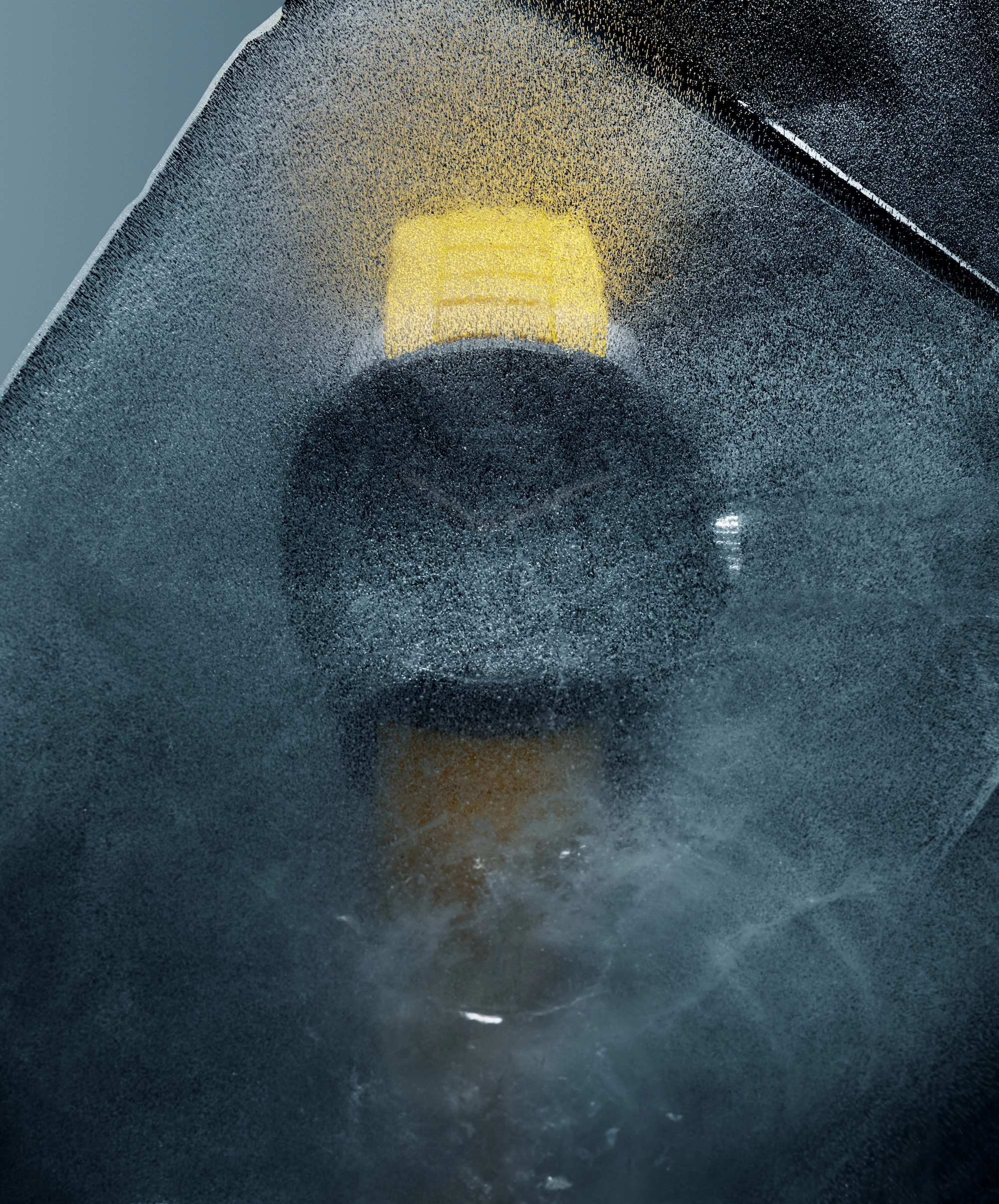 Black wristwatch with a yellow strap partially covered in ice and frost.
