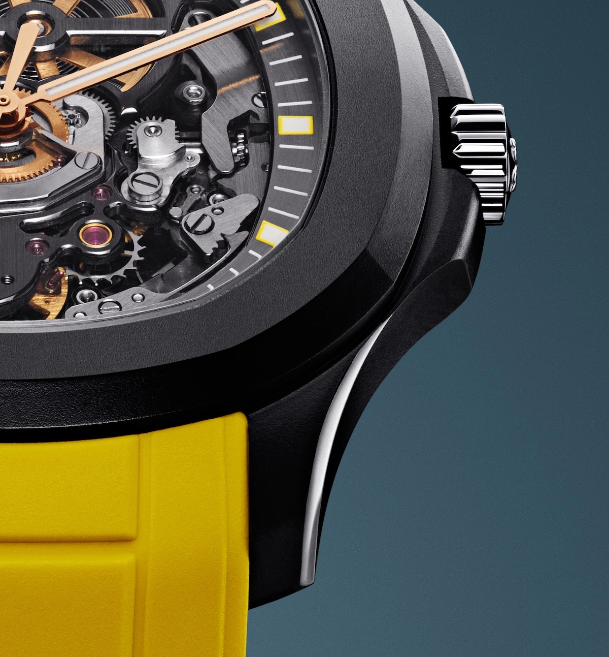 Close-up of a mechanical watch with visible gears, black case, silver crown, and yellow band.