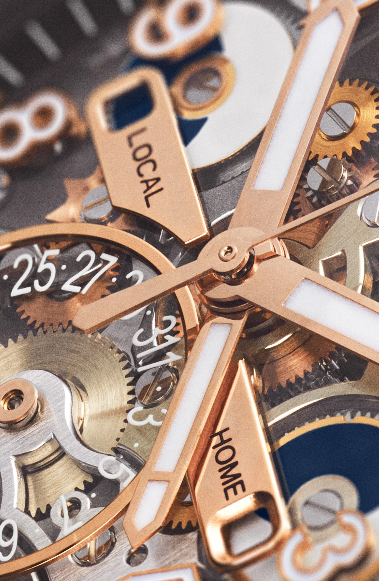 Close-up of rose gold watch hands and gears showing 'LOCAL' and 'HOME' time markers.