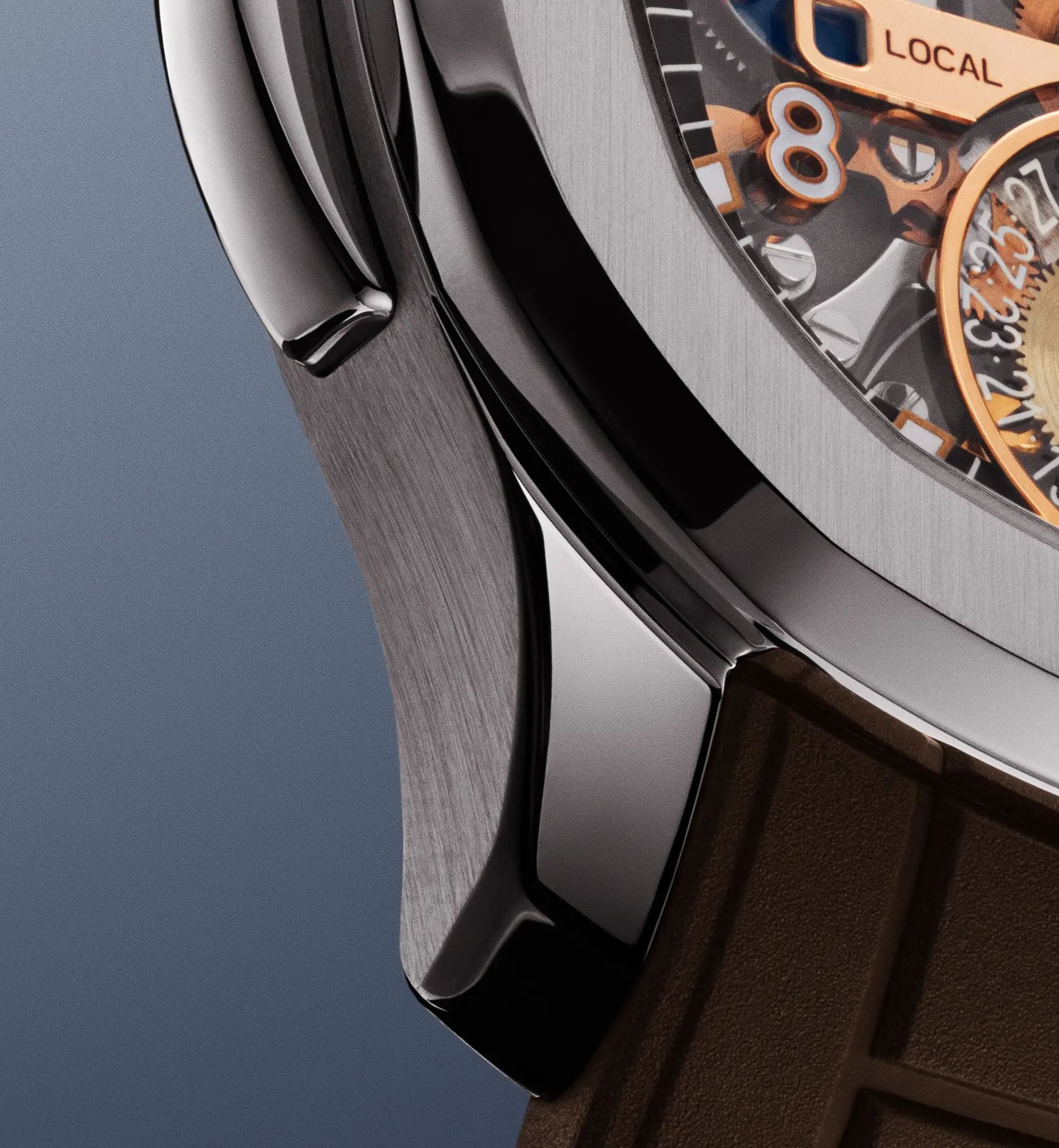 Close-up of a luxury watch case with brushed metal finish, visible screws, and a brown strap.