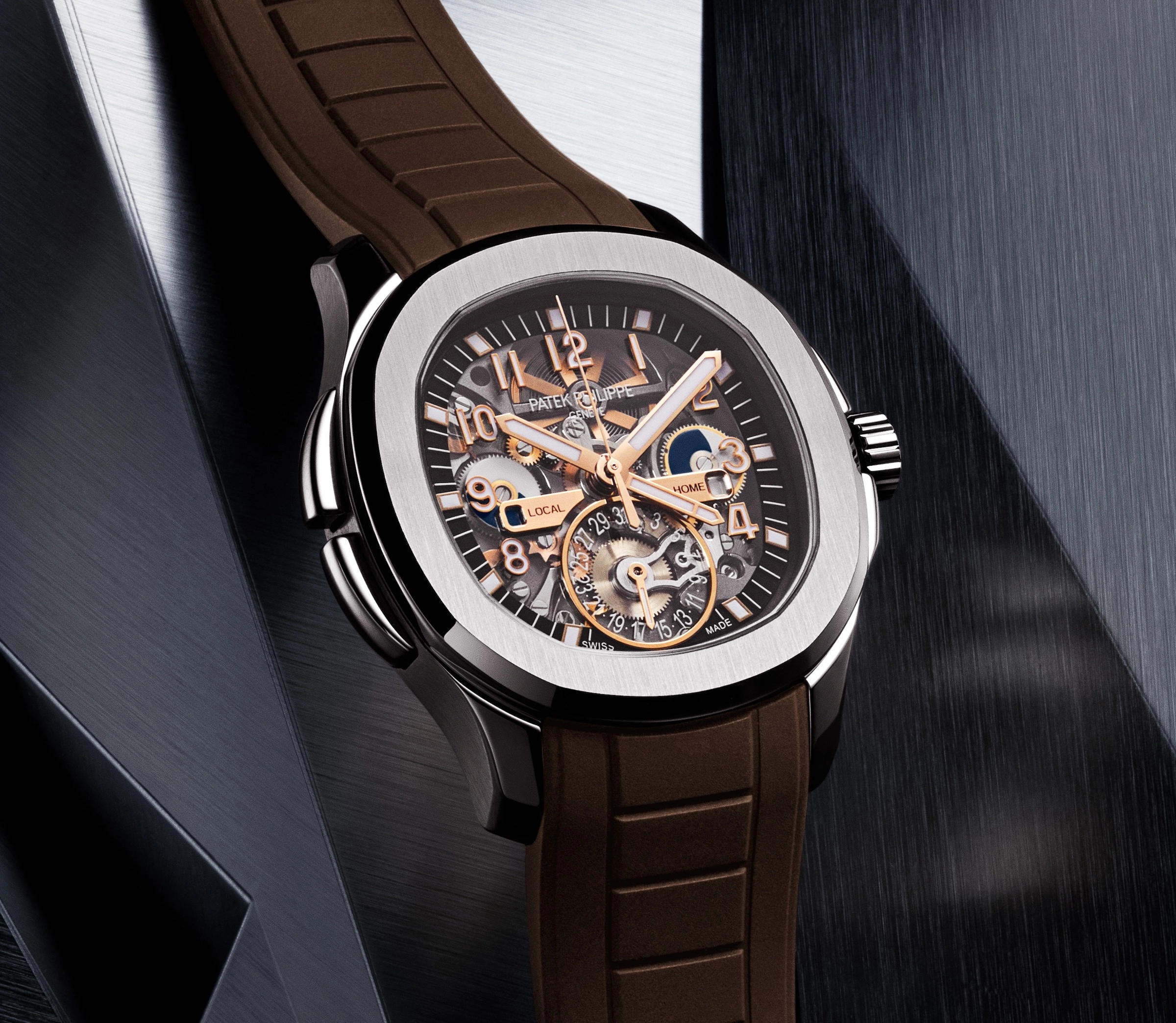 Close-up of a Patek Philippe watch with a transparent dial and brown rubber strap.