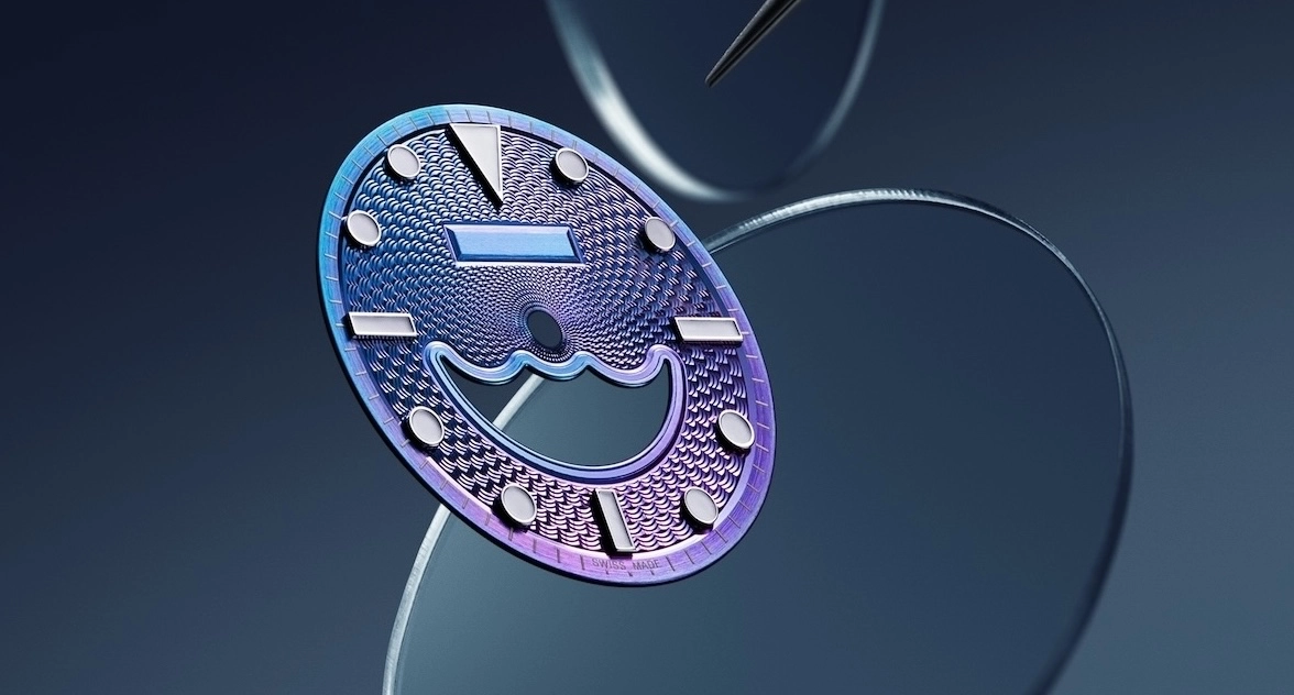Close-up of a purple-blue textured watch dial with silver hour markers and a cutout wave design.