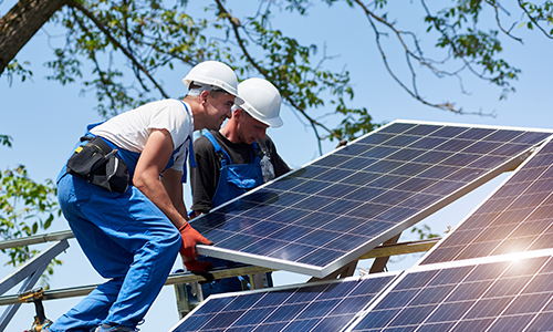 Zwei Monteure installieren gemeinsam ein Photovoltaik-Modul – professionelle Montage für maximale Energieeffizienz