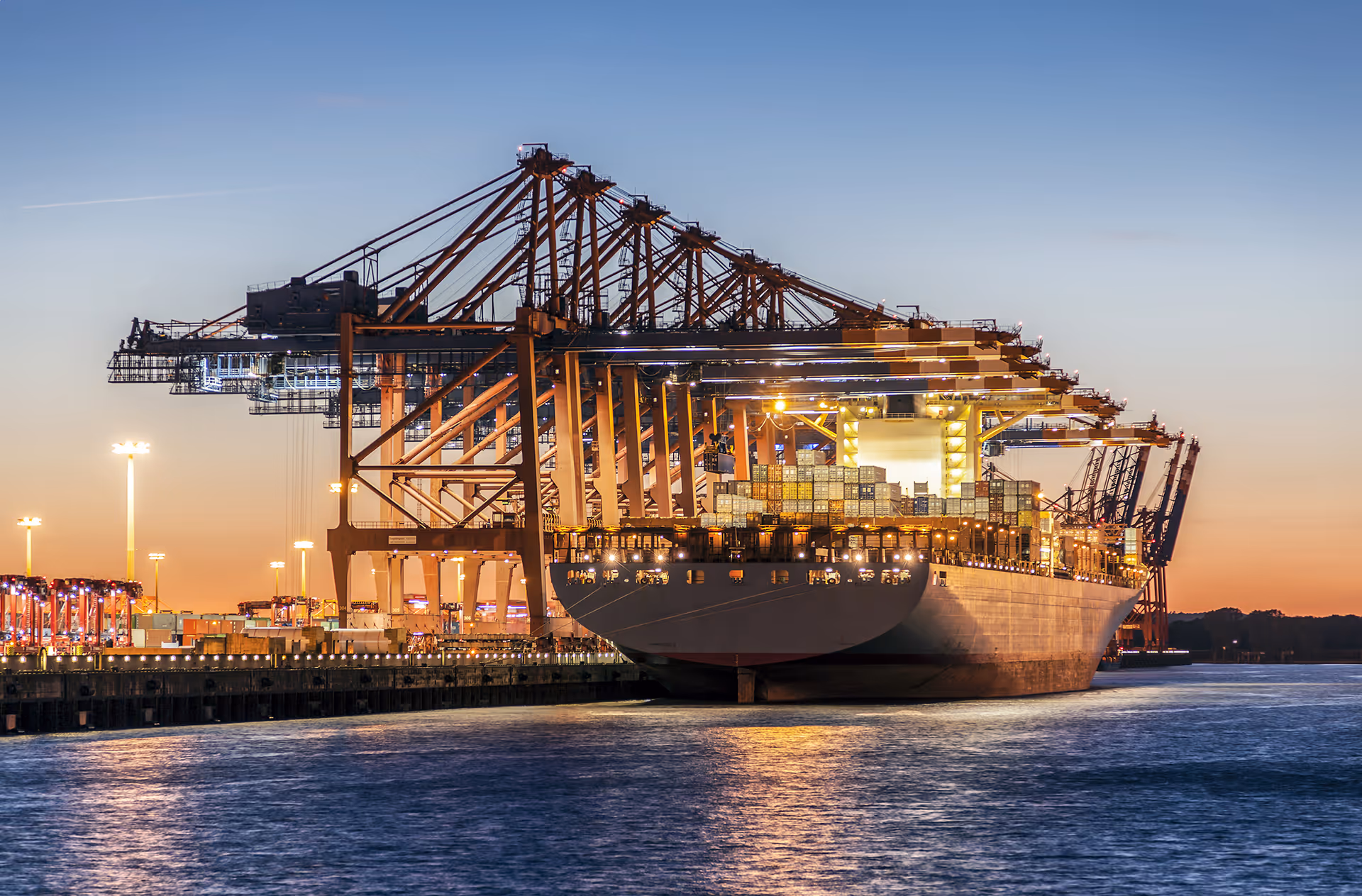 Container ship being loaded at an Australian port at sunset, representing maritime operations and supply-chain security