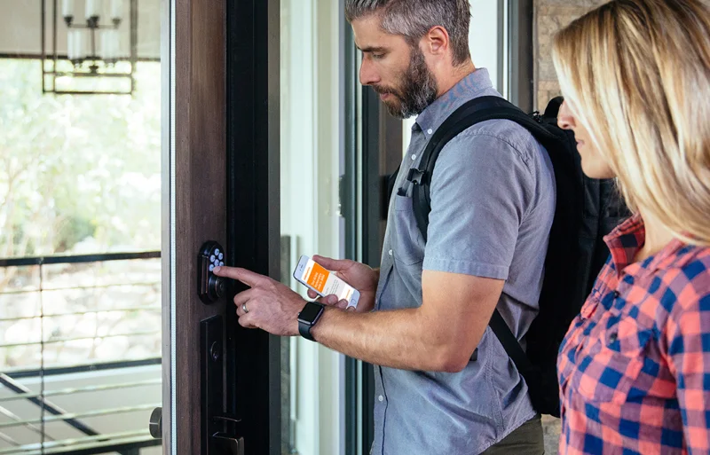 A man holding a bottle of sunscreen while standing next to a woman.
