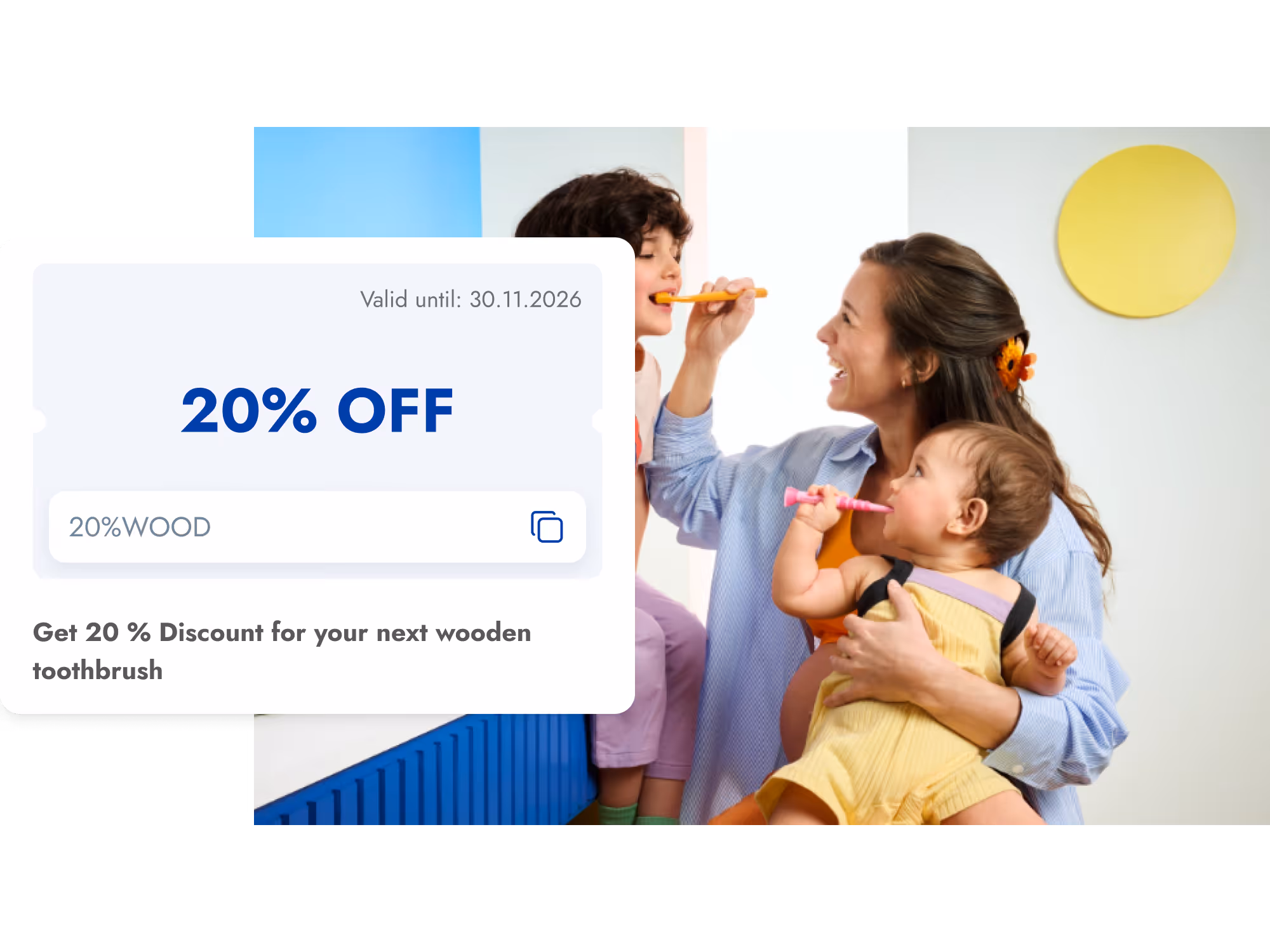 Mother holding a baby and brushing an older child's teeth, with a 20% off discount coupon for wooden toothbrushes displayed.