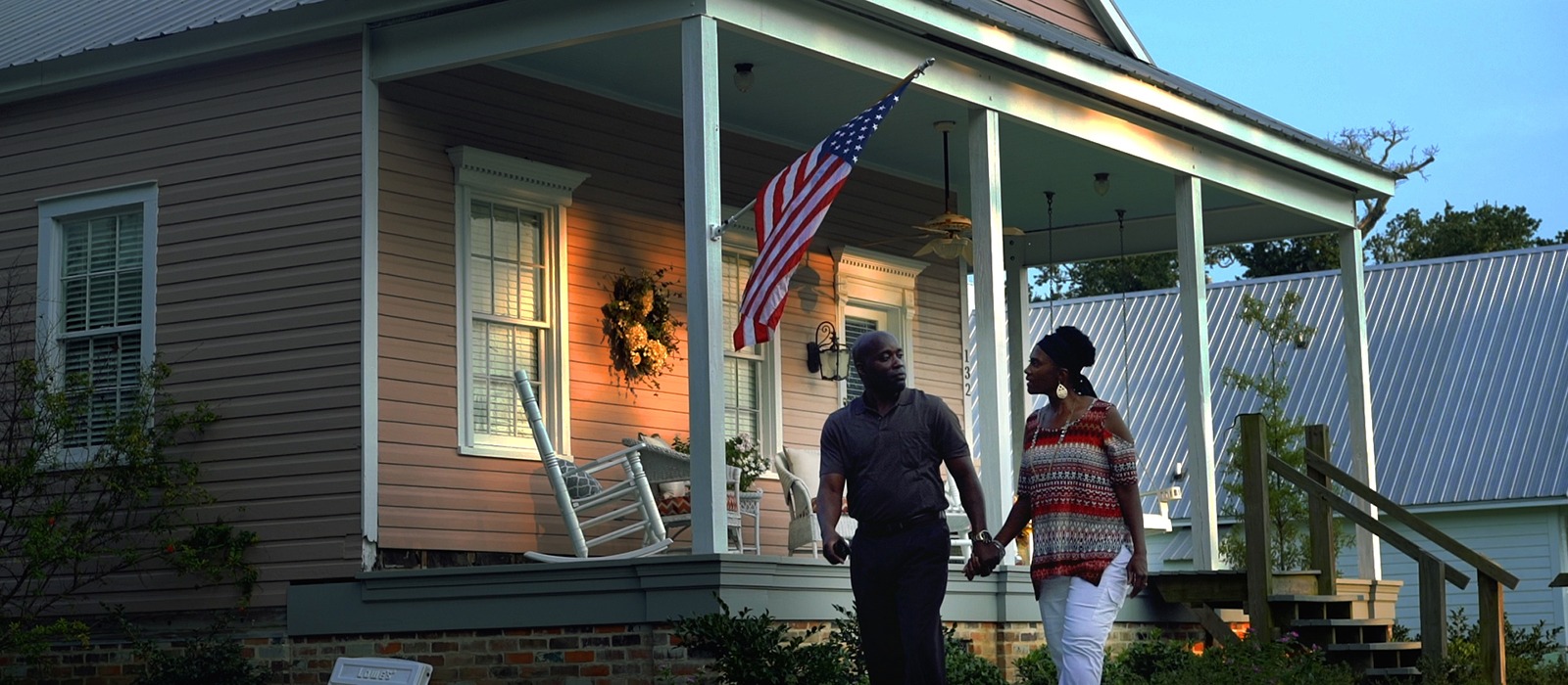 A couple walks in front of their new home