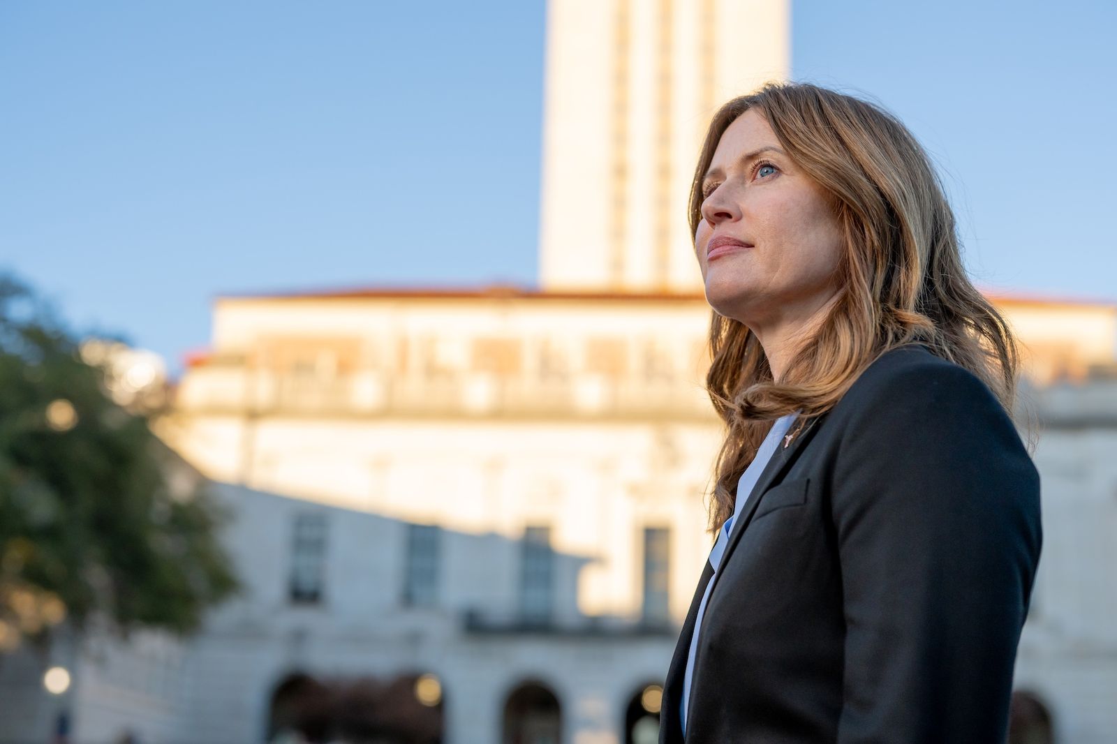 A woman looks off into the distance on UT campus