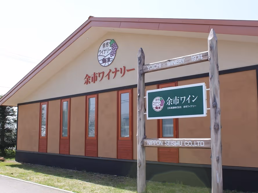 Exterior view of Yoichi Winery building with wooden sign displaying Yoichi Winery 1974 and Nippon Seishu Co., Ltd.