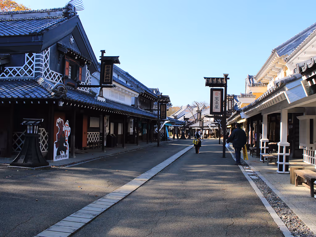 Street view of Noboribetsu Date Jidai Village with traditional Japanese buildings under a clear blue sky.