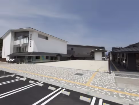 Modern white and gray roadside station buildings with an empty parking lot under a clear blue sky.