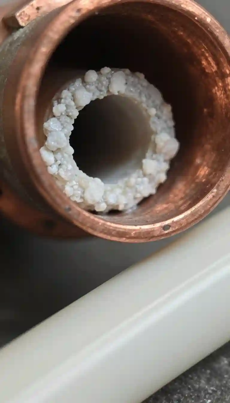 Dépôts de calcaire blanc incrustés dans canalisation cuivre ancien versus tuyauterie PER neuve Blacé