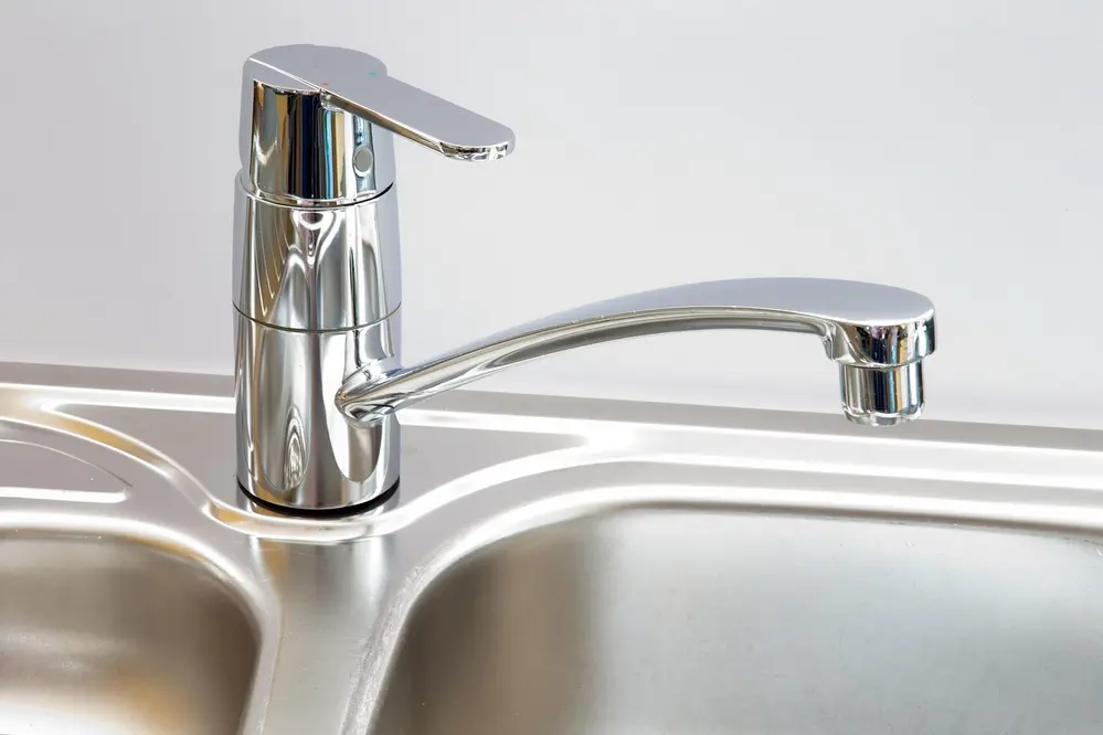 Robinet de cuisine en acier inoxydable brillant, vu de près. Crédits : freepik.com