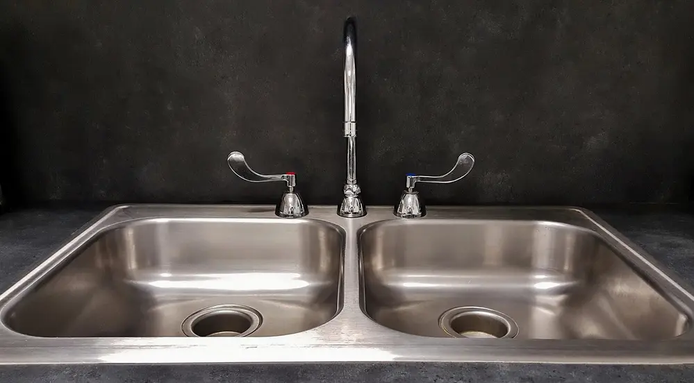 3-Évier de cuisine en inox avec robinet et poignées. Crédits : freepik.com