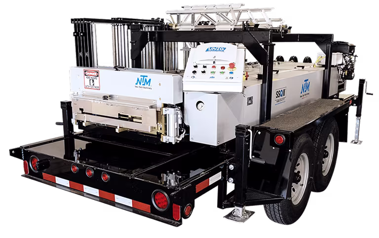 New Tech Machinery branded industrial equipment trailer with control panel and wheels.