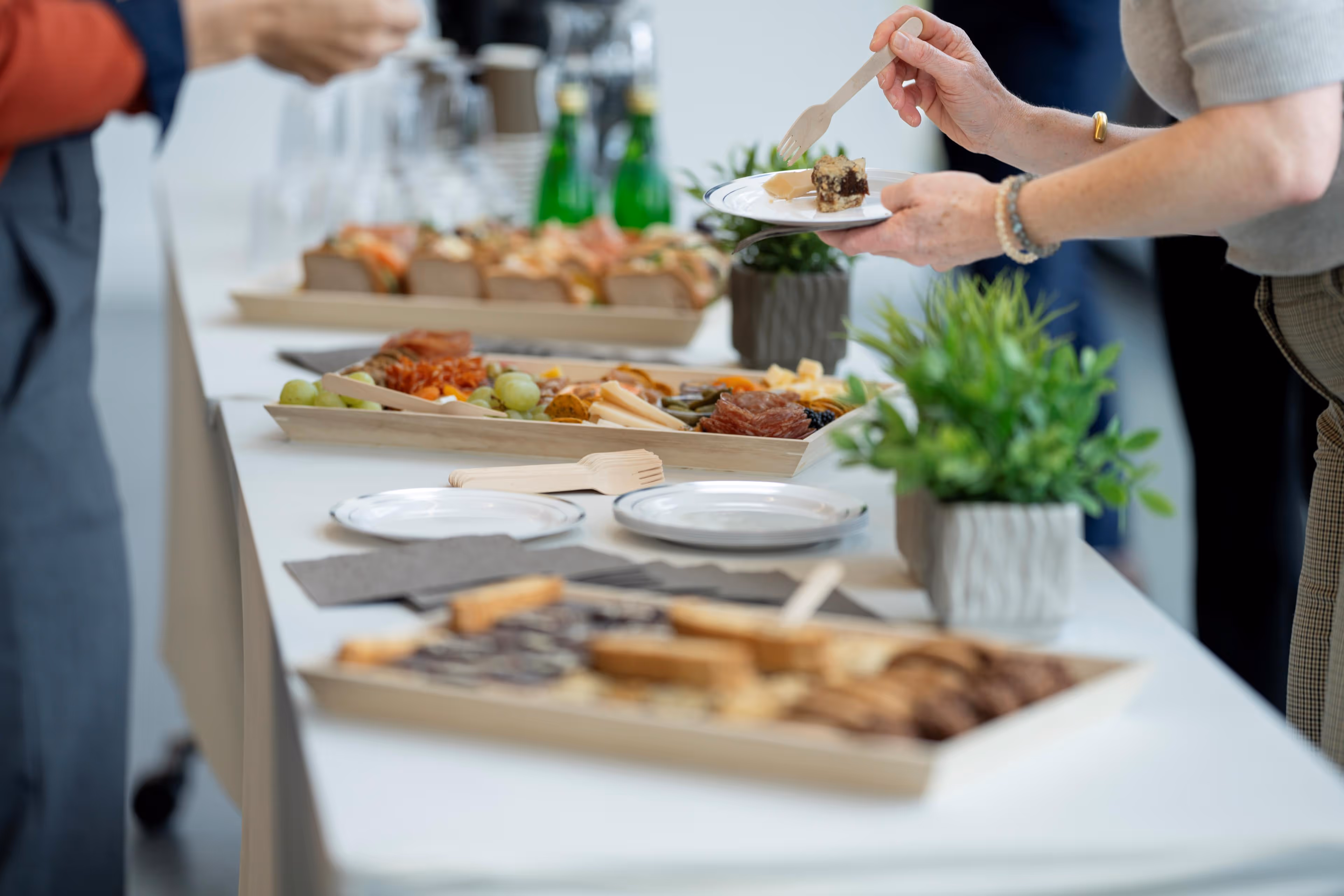 Food being served at a buffet table in a well-lit banquet hall.