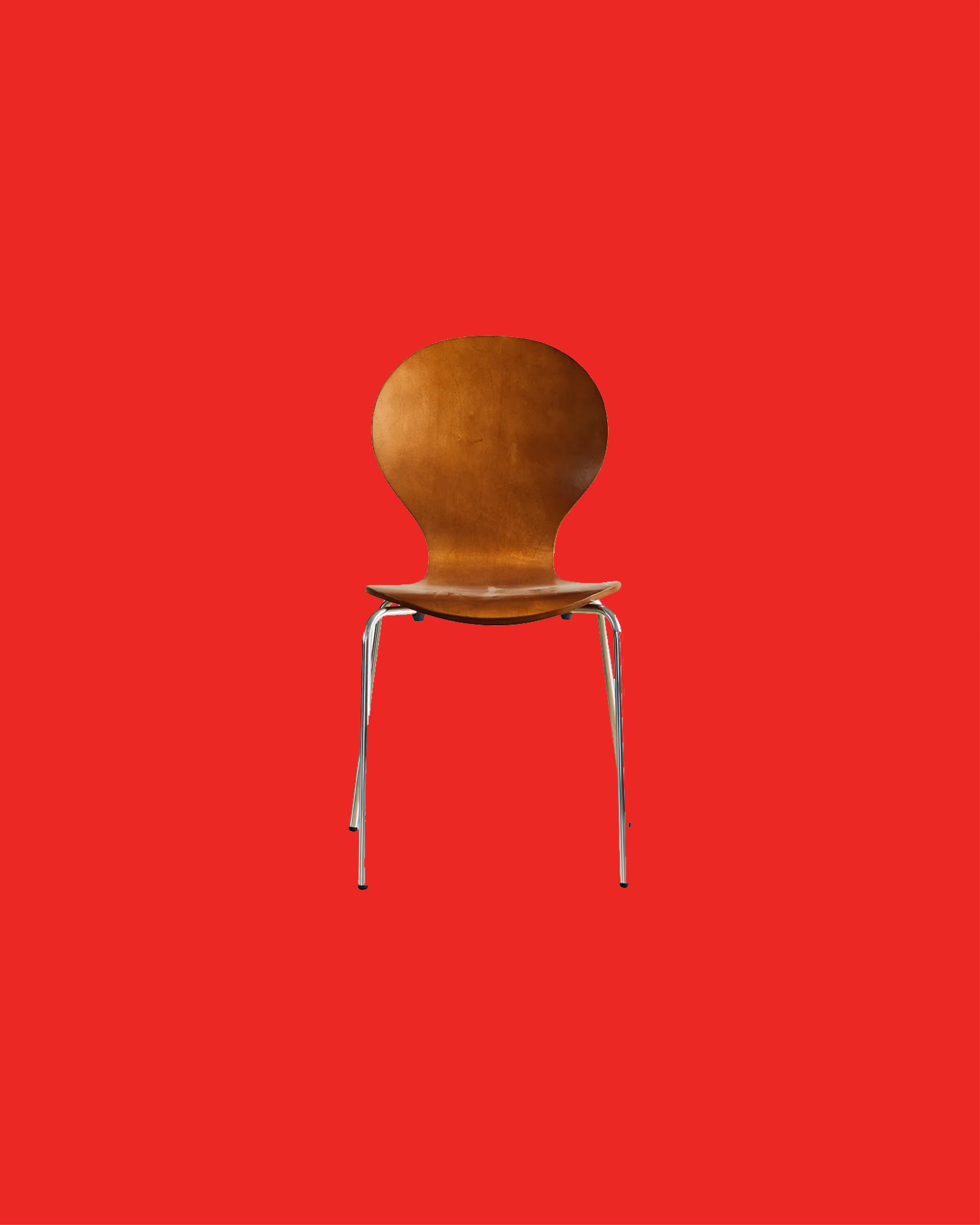 Mid-century modern wooden chair with chrome legs on a red background.