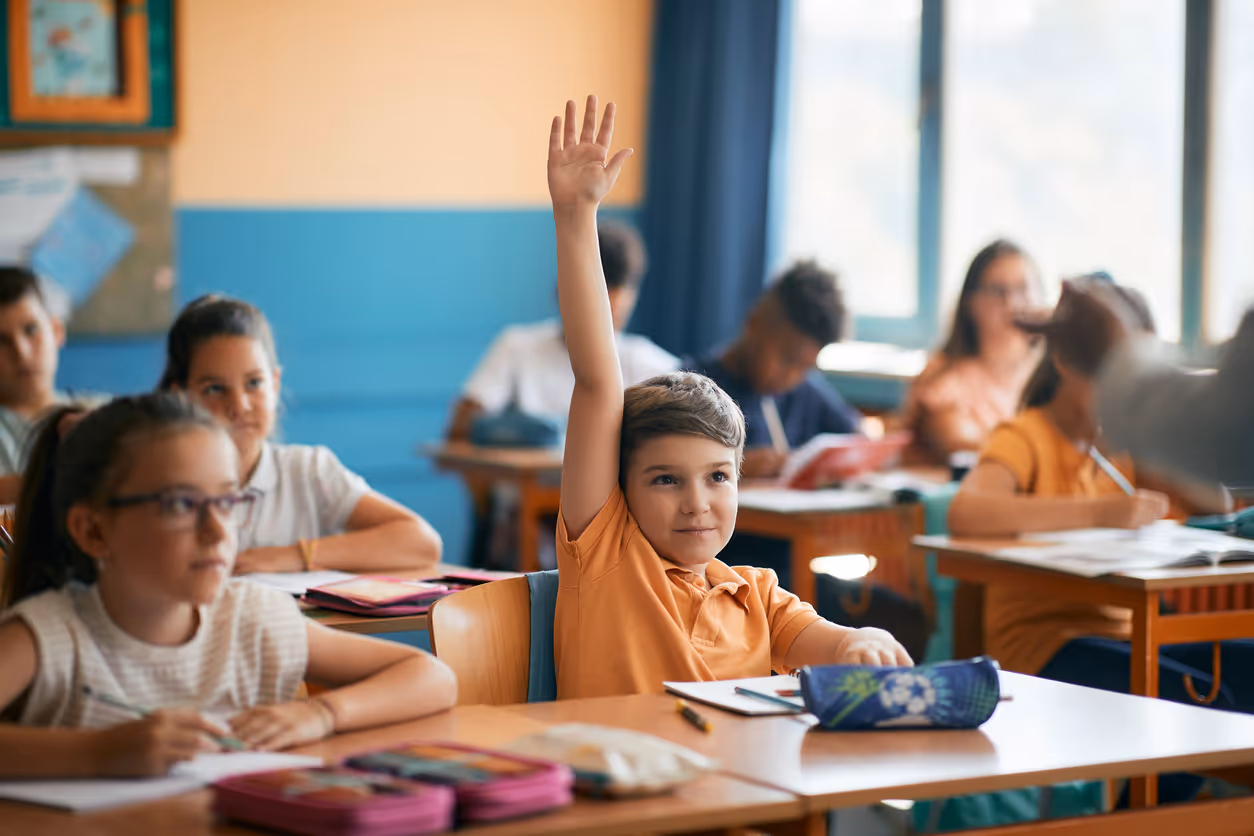 Child raising their hand during a real-time autism evaluation in a classroom setting 
