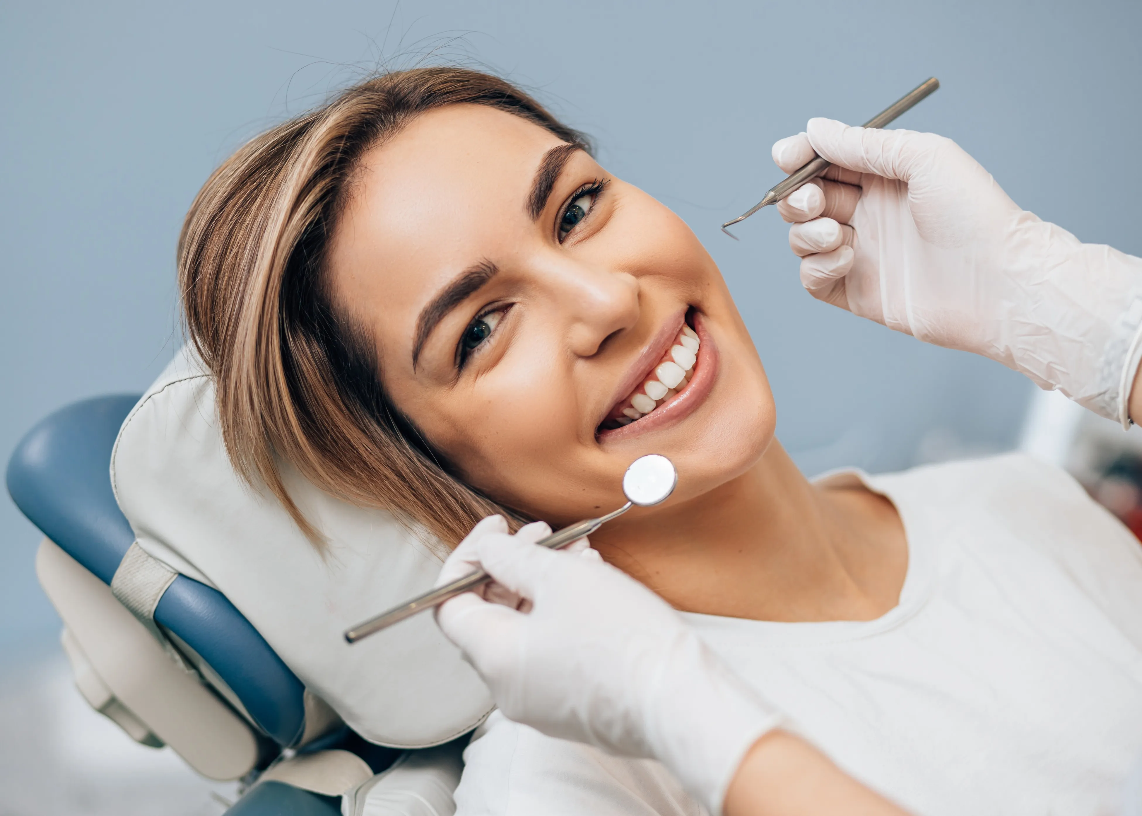 A woman sitting in a dentist chair getting her teeth cleaned
