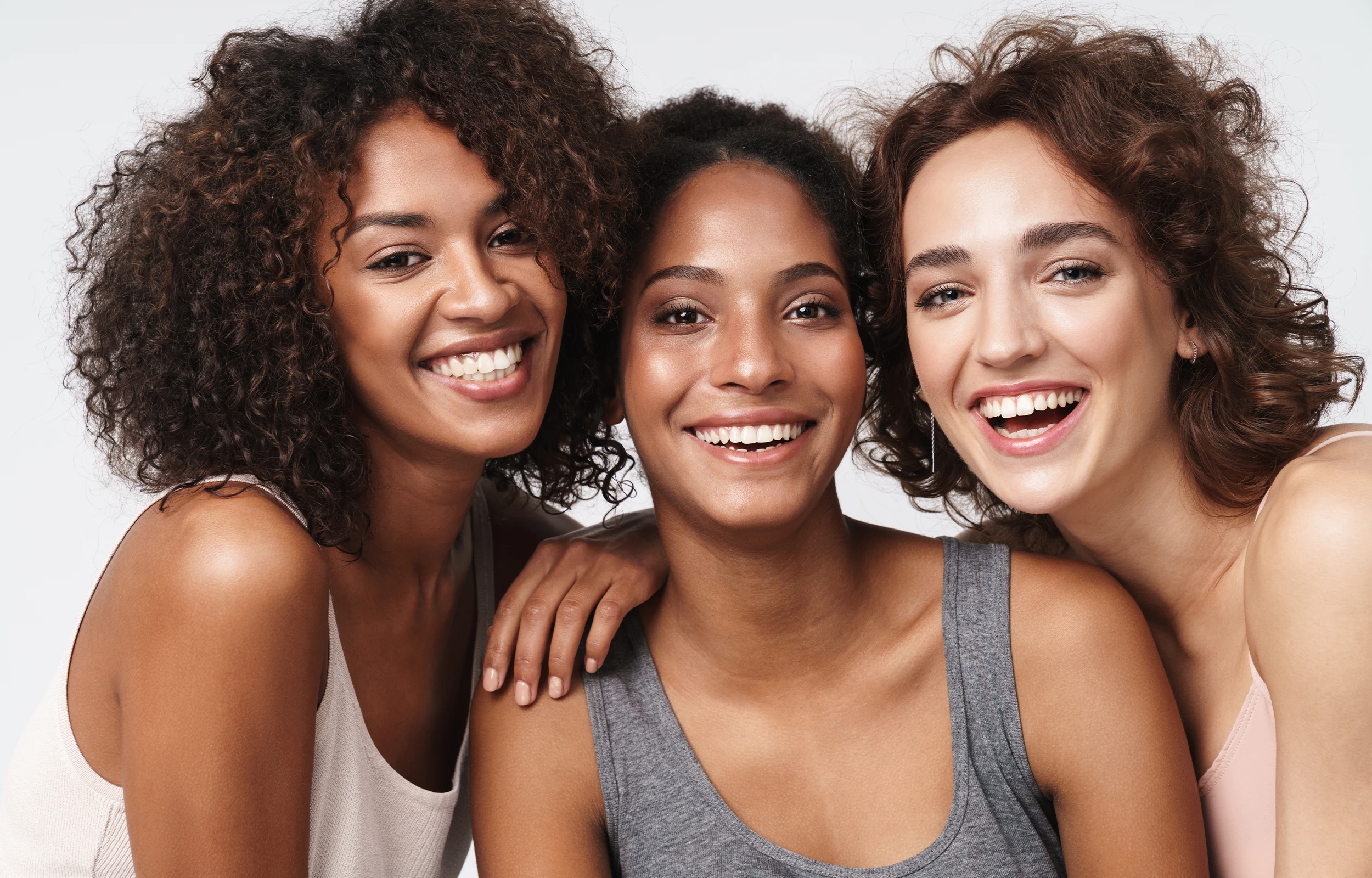 Three women are smiling and posing for a picture.