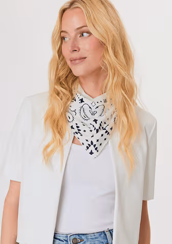 Blonde woman wearing a cream-colored cable knit sweater with a half-zip collar.