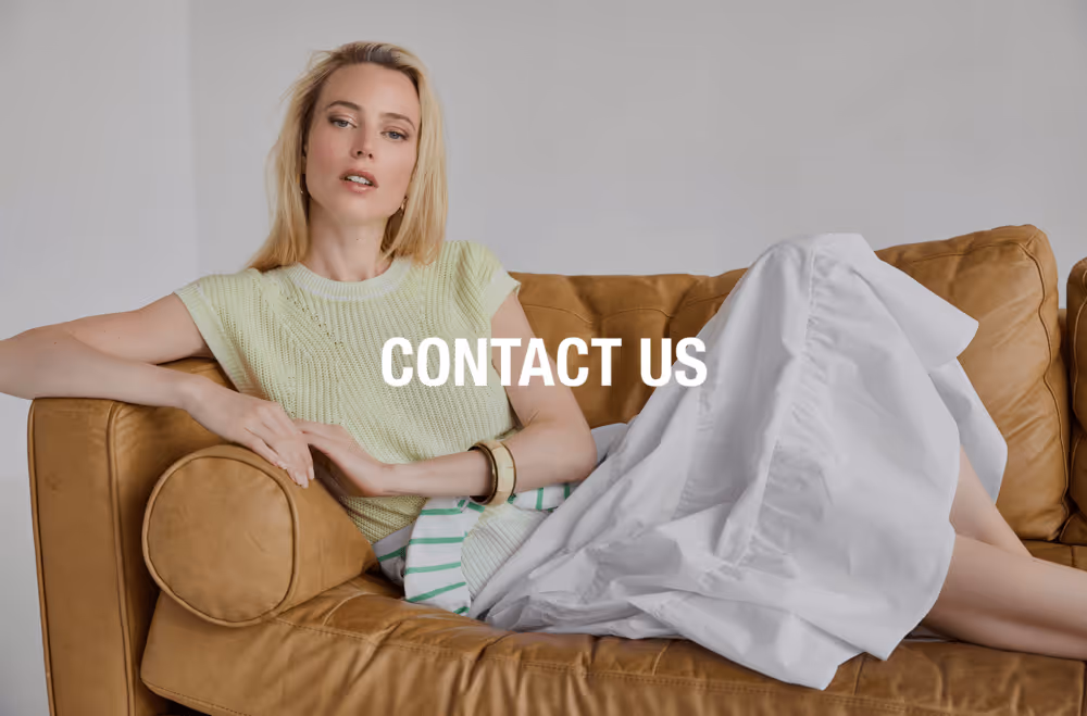 Woman wearing a silver puffer jacket over a grey sweater with pearl embellishments and a grey cap, promoting a holiday lookbook.