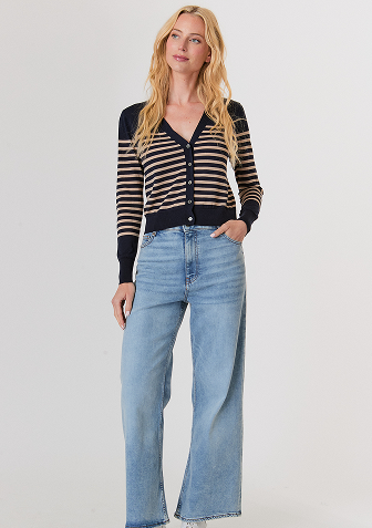 Blonde woman wearing a cream-colored cable knit sweater with a half-zip collar.