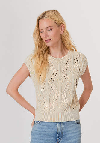 Woman wearing a black mesh sweater and a black leather midi skirt with studded high heel sandals.