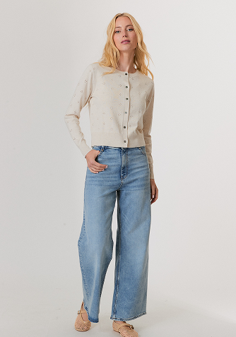 Person wearing beige tapered pants with elastic cuffs and a matching beige sweater, paired with brown sandals.