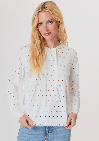 Blonde woman wearing a cream-colored cable knit sweater with a half-zip collar.