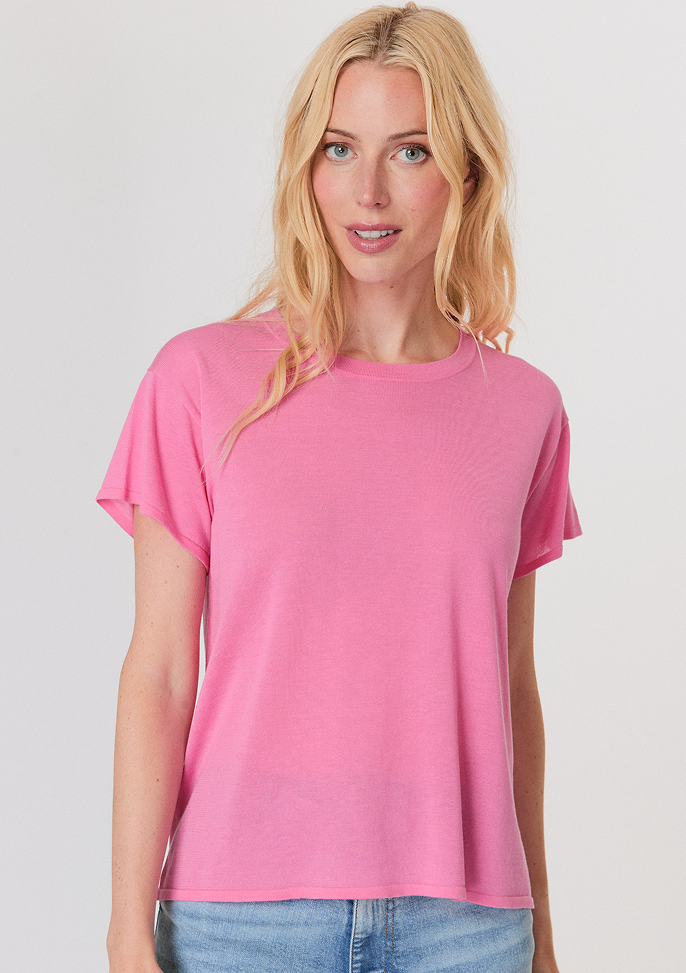 Blonde woman wearing a dark brown cropped cardigan with a satin ribbon tie over a white top and light blue high-waisted jeans.