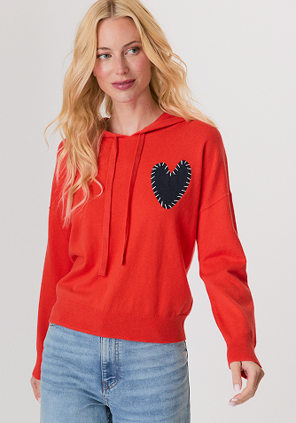 Woman wearing a black mesh sweater and a black leather midi skirt with studded high heel sandals.