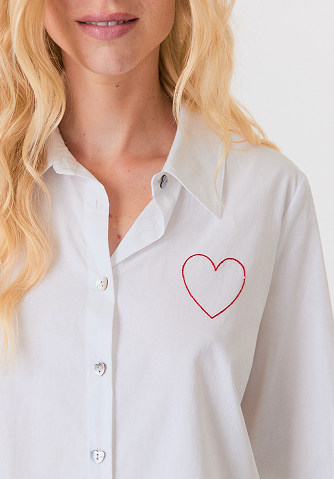 Blonde woman wearing a cream-colored cable knit sweater with a half-zip collar.