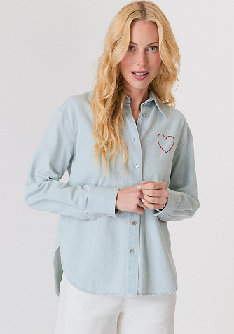 Blonde woman wearing a cream-colored cable knit sweater with a half-zip collar.