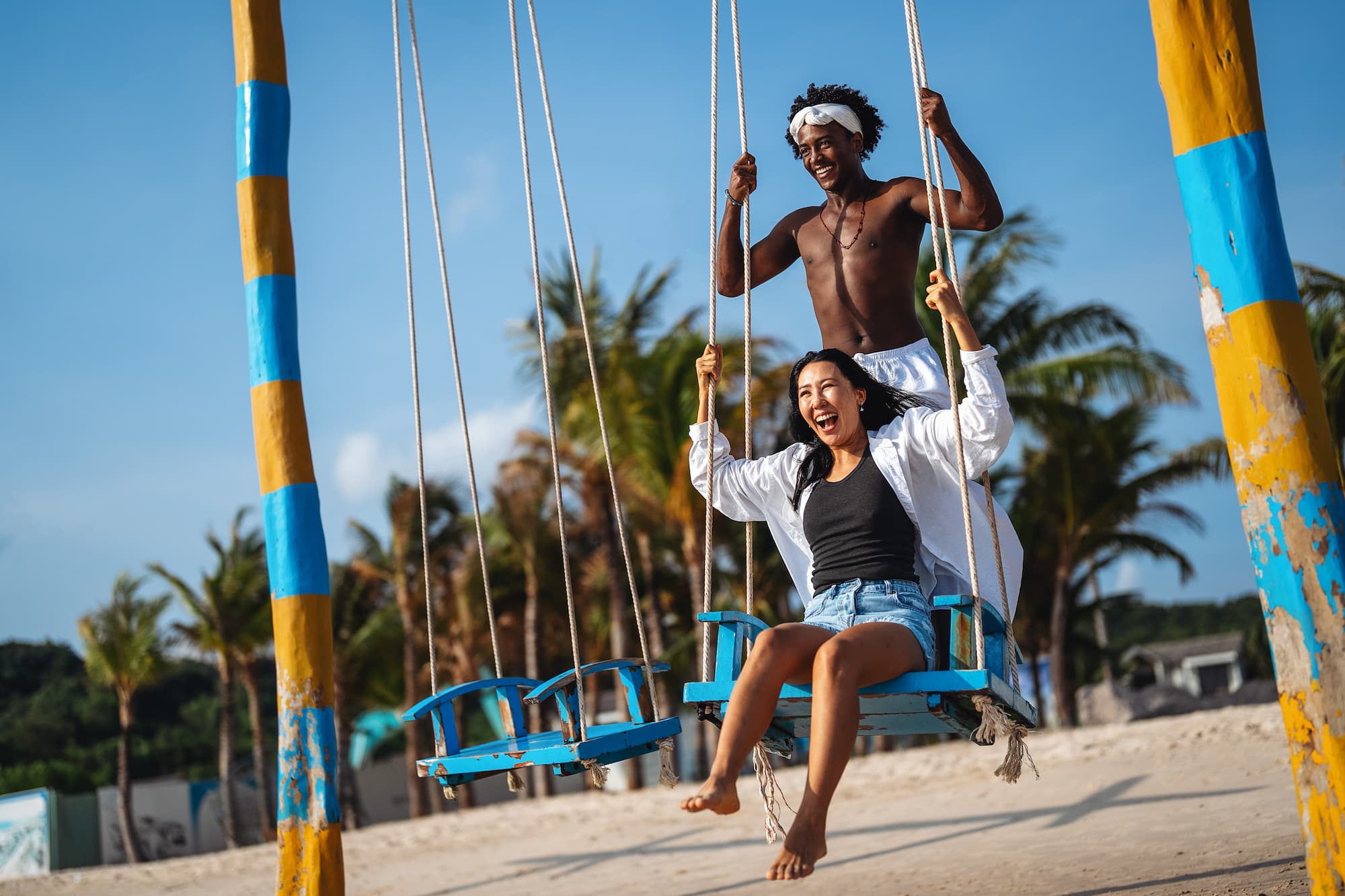 couple enjoying beach on swings