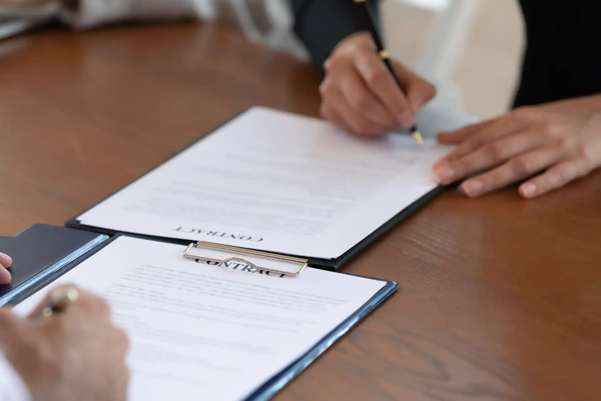 Two professionals signing a contract during a business acquisition or purchase price allocation agreement