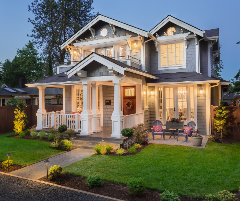 Craftsman-style home with charcoal gray siding, white trim, and covered front porch at dusk