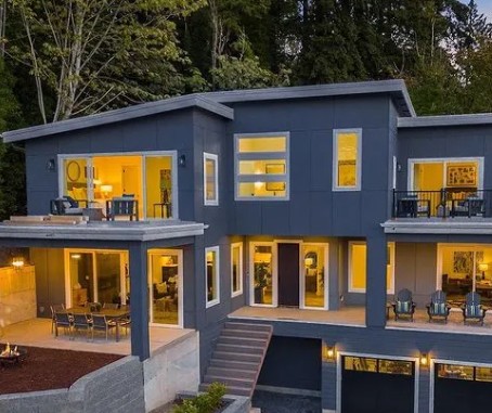 Modern multi-level home featuring large Infinity from Marvin windows and doors, showcasing expansive glass walls, clean architectural lines, and warm interior lighting.