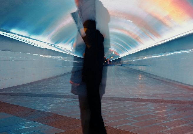 Artistic but photorealistic image of a person in motion in a subway area.