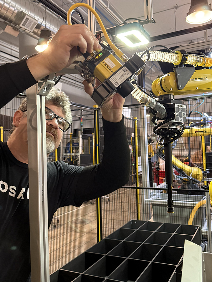 An OSARO employee fixes an EOAT on a robot
