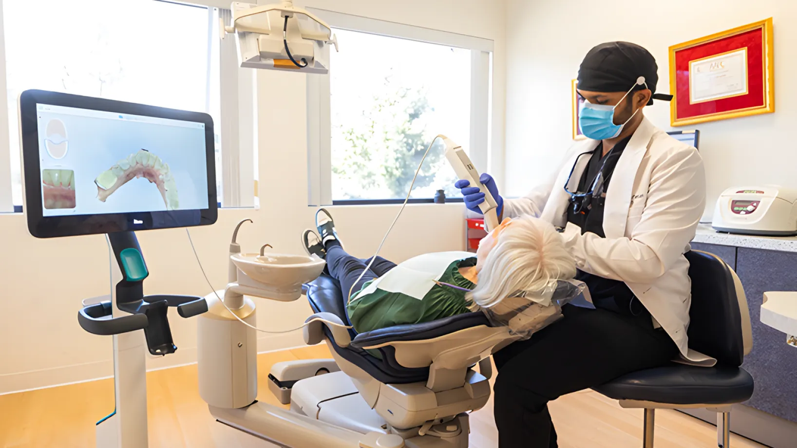 A dentist examines a patient's teeth using a digital scanner in a dental office.