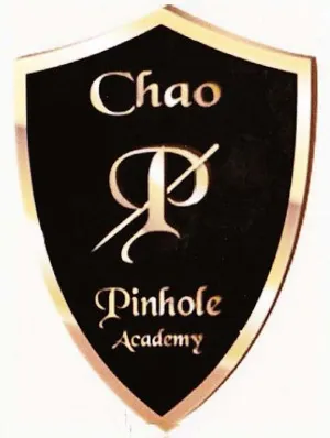 Shield-shaped emblem with the text "Chao Pinhole Academy" in elegant font on a dark background.