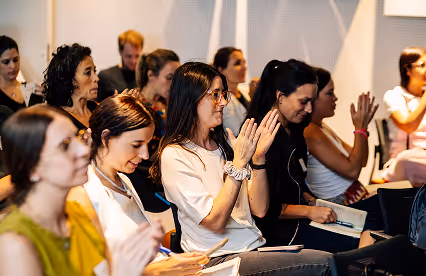 A presenter explains creative strategies in front of a slide titled "Ser creativos en nuestro always-on" during a talk.