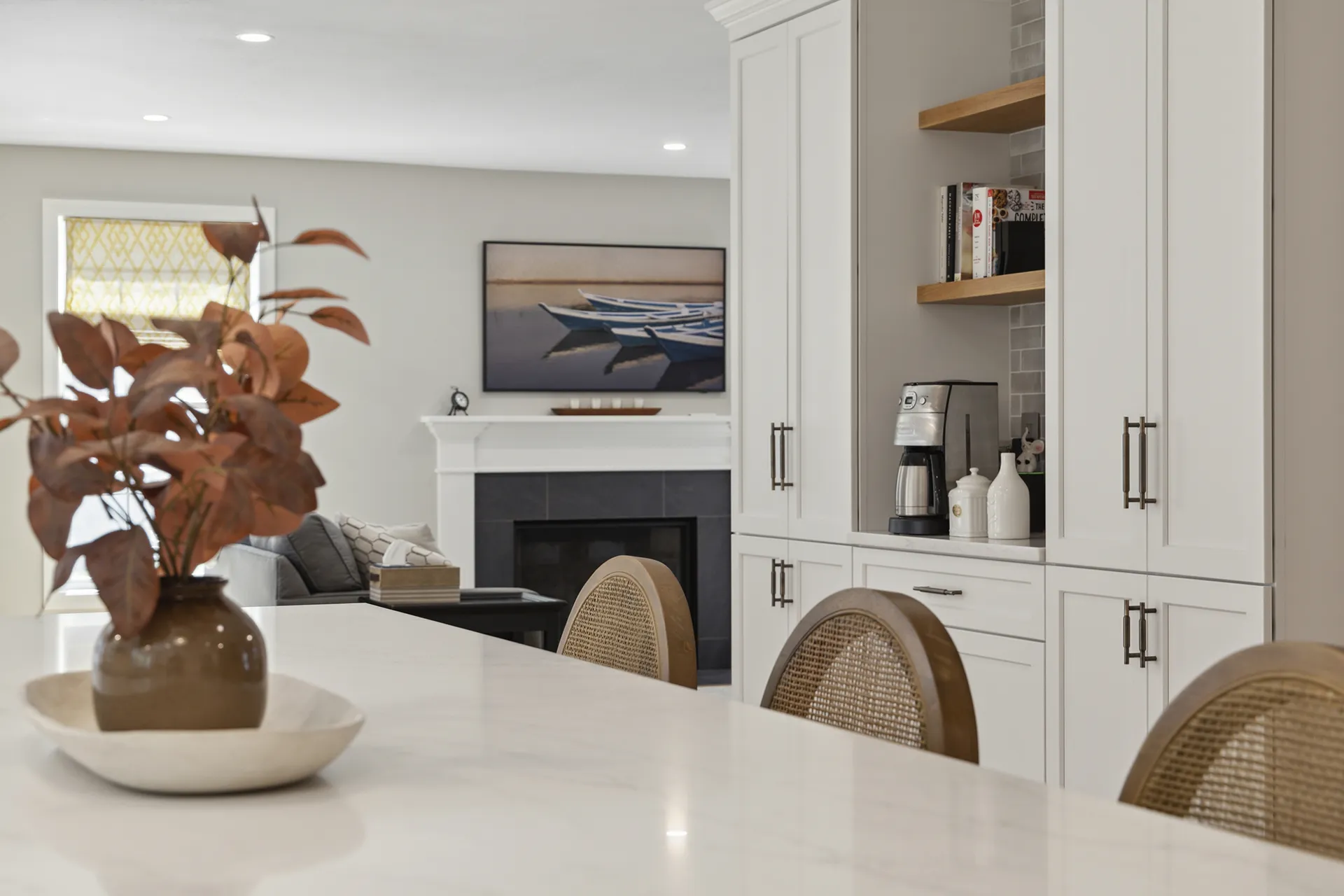 View from kitchen island into living room with fireplace and built-in cabinetry.