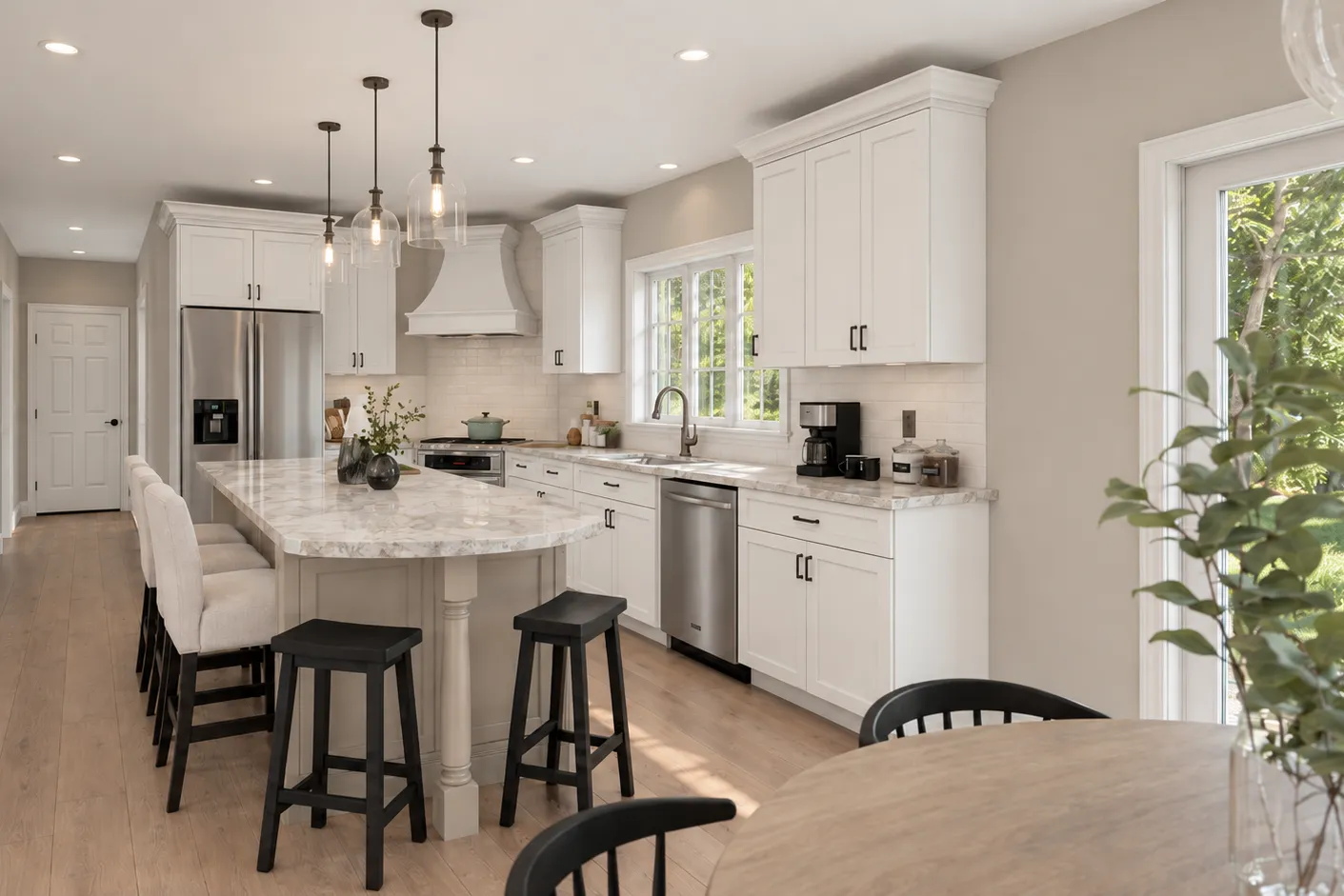 Kitchen remodel in Londonderry, NH — enlarged island with seating for five, glass pendants and white shaker cabinetry by Oak Hill Design & Build