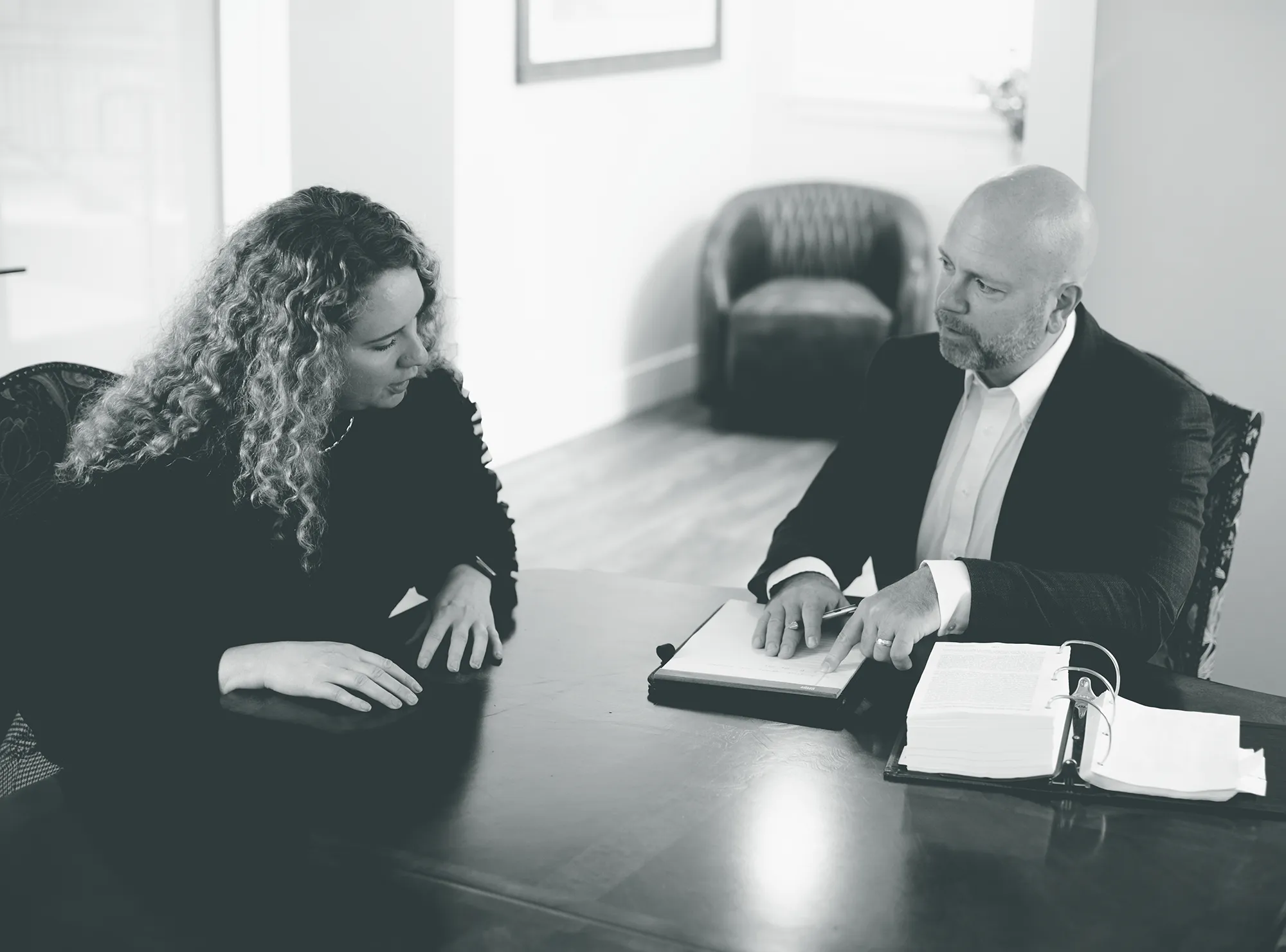 Derek Larwick at a desk talking with a client