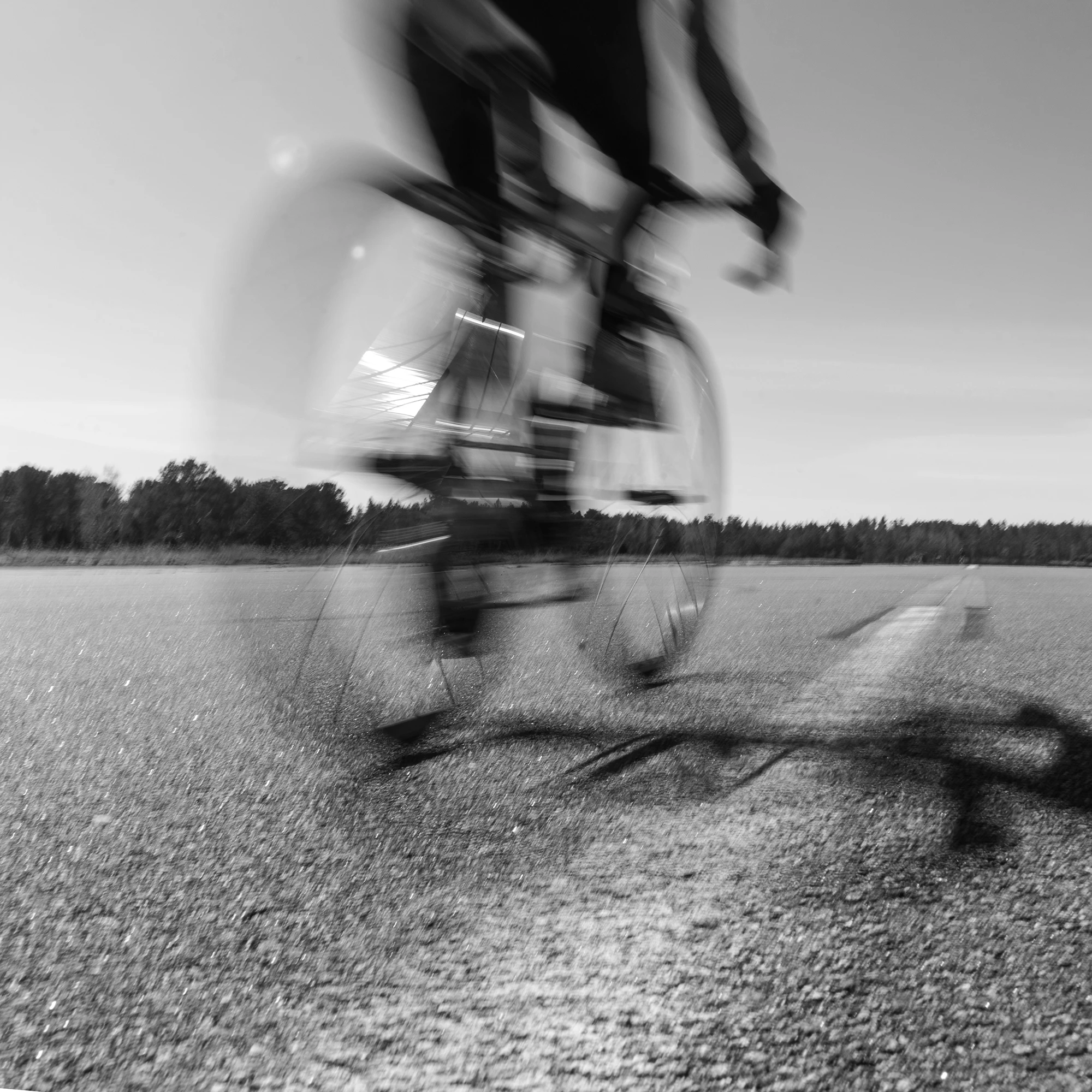 Motion blur of cyclist riding fast on open road