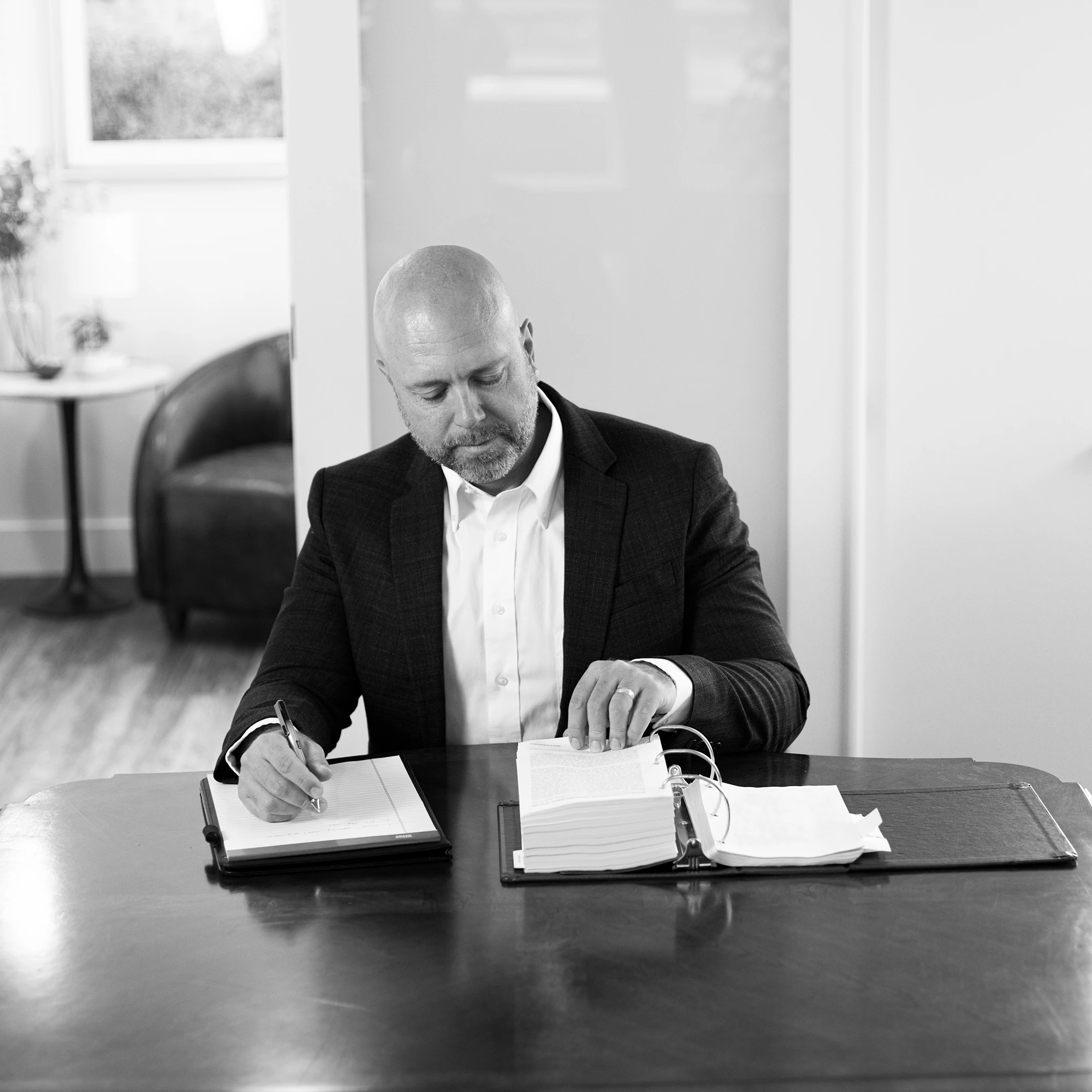 Derek Larwick reading legal documents at a desk