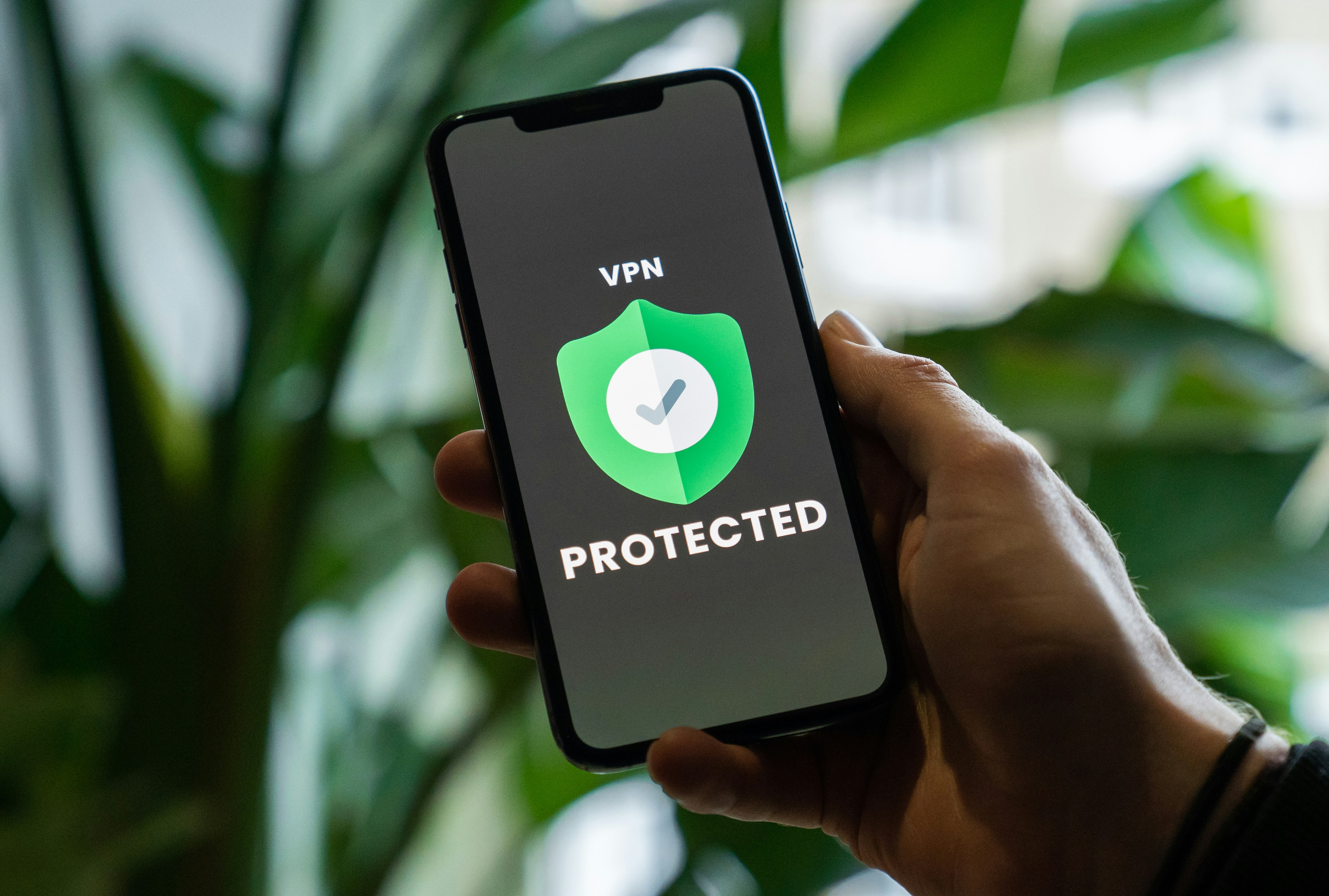 a phone held in a mans hand with VPR PROTECTED displayed on the phone screen